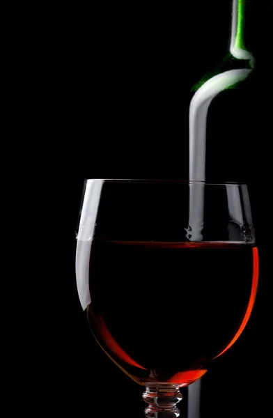 Vino tinto en vaso y botella aislado en negro — Foto de Stock