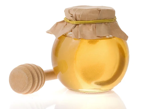 Pentola di vetro piena di miele e bastone isolato su sfondo bianco — Foto Stock