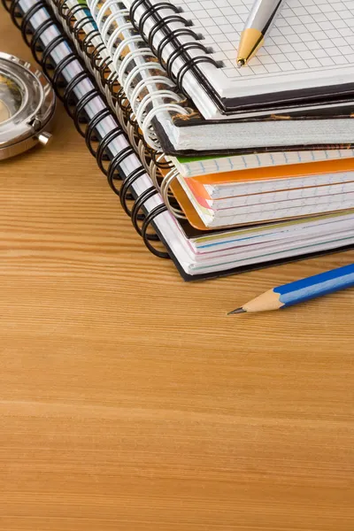 Cuaderno y bolígrafos sobre fondo de madera — Foto de Stock