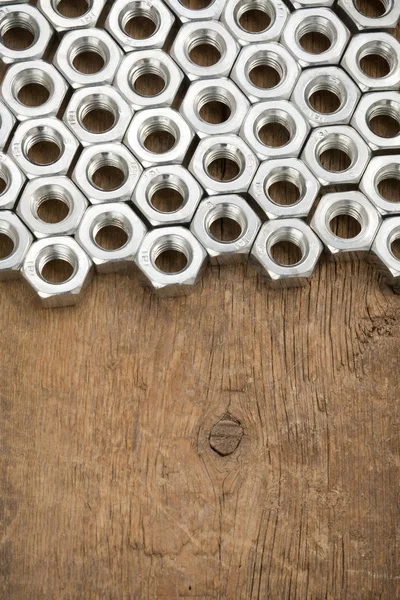 Narzędzia metalowe nakrętki na tle drewna — Zdjęcie stockowe