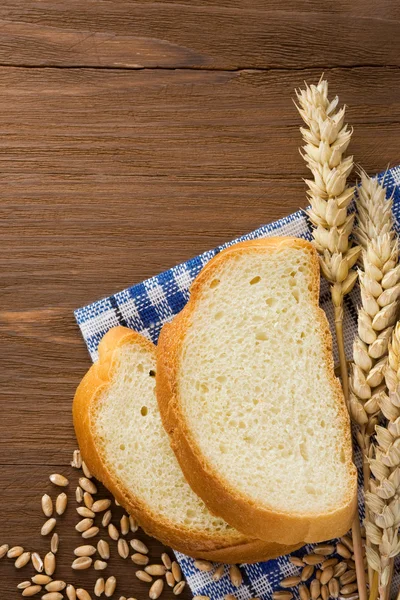 Pão em fatias e espigas de trigo — Fotografia de Stock