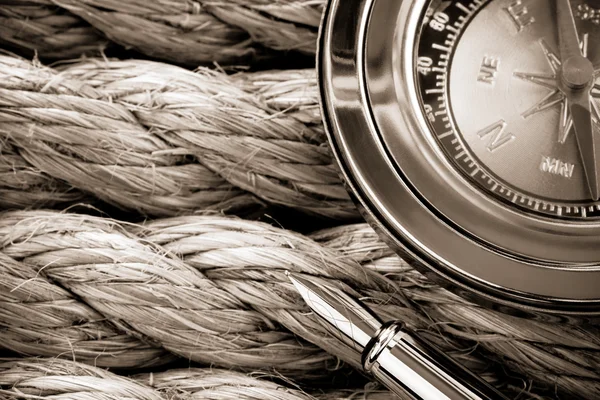 Compass with pen on ship ropes — Stock Photo, Image