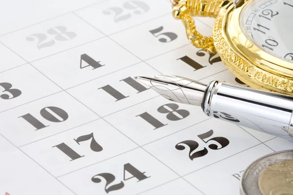 Inchiostro penna e moneta denaro sul calendario — Foto Stock