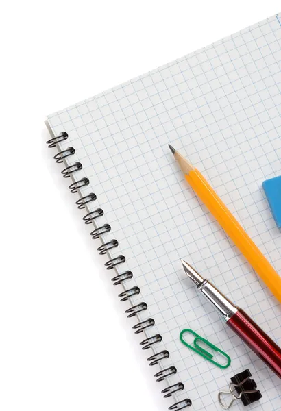 School supplies on checked notebook — Stock Photo, Image