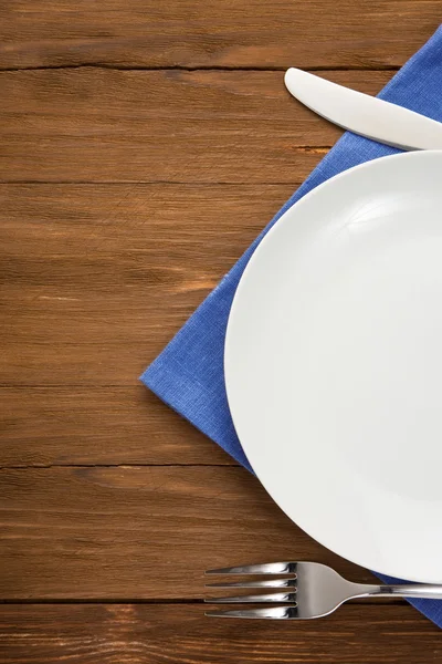 Plate, knife and fork on wood — Stock Photo, Image