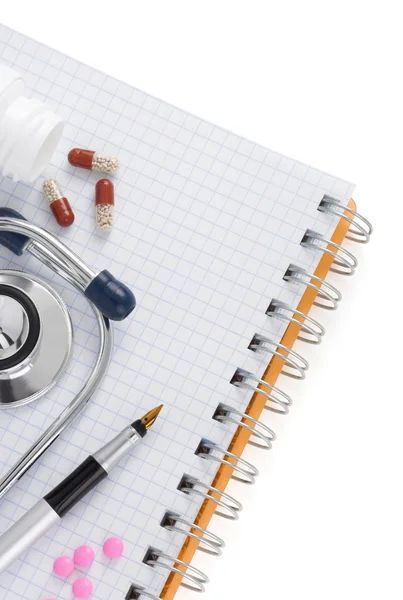 Stethoscope with pills and notebook — Stock Photo, Image