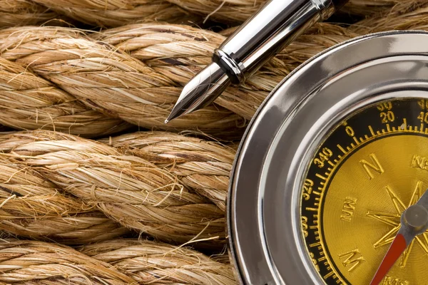 Compass with pen on ship ropes — Stock Photo, Image