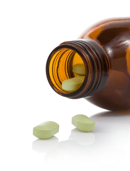 Tabletten und Flasche auf Weiß — Stockfoto