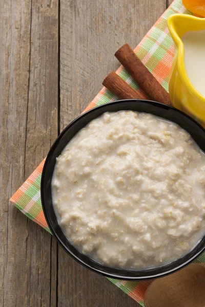 Bowl of oatmeal on wood — Stock Photo, Image