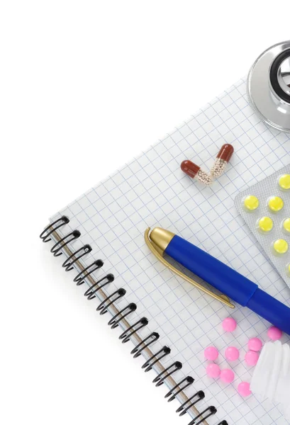 Stethoscope with pills and notebook — Stock Photo, Image