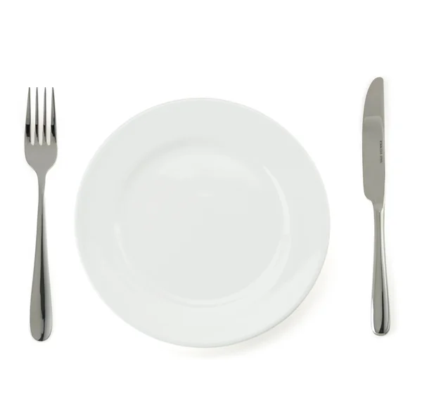 Тарелка, нож и вилка на белом — стоковое фото