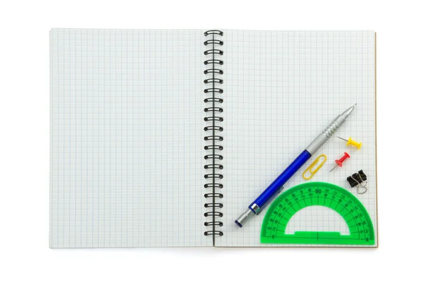 School supplies on checked notebook — Stock Photo, Image