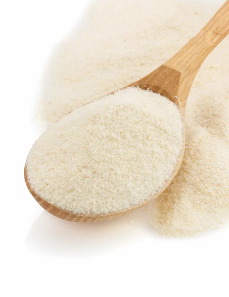 Semolina flour in spoon on white — Stock Photo, Image