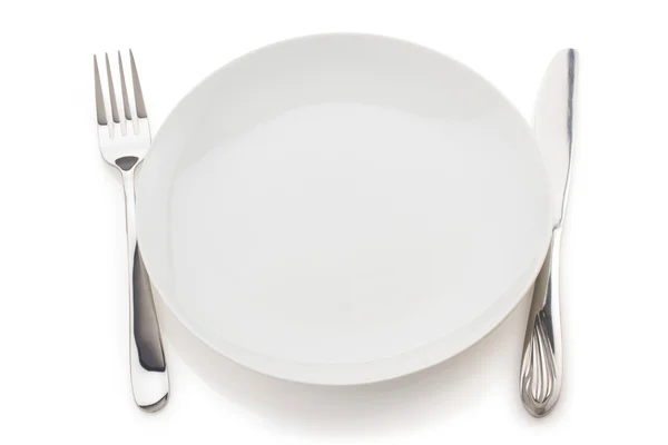 Assiette, couteau et fourchette sur blanc — Photo
