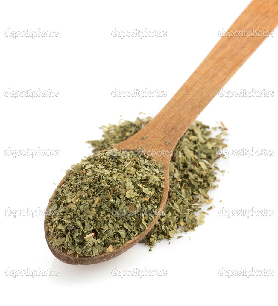 dried green spices and spoon on white