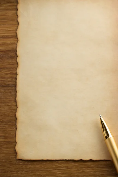 Золотая ручка на пергаменте — стоковое фото