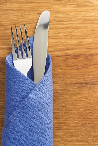 Cuchillo y tenedor en la servilleta en madera — Foto de Stock