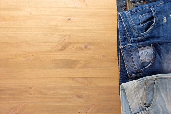 Jeans Blu Denim Tavolo Legno Jeans Mucchio Sfondo Legno Texture — Foto Stock