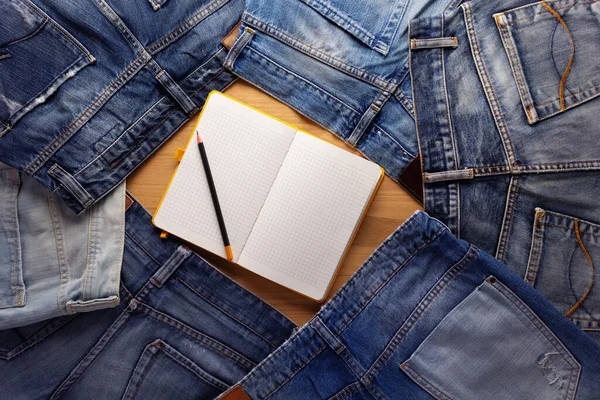 ノートとブルーのジーンズのデニムポケットの背景の質感 ジーンズスタックヒープ — ストック写真