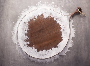 Tahta kesme ve un tozu, arka plandaki taş masada. Tahta pizza tahtası.