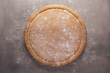 Tahta kesme ve un tozu, arka plandaki taş masada. Tahta pizza tahtası.