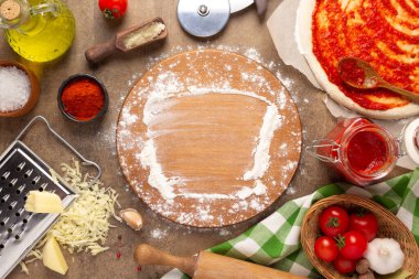 Pizza kesme tahtası ve un ev yapımı yemek ya da yemek masasında. Pizza malzemesi masa başı arka plan görünümünde. Mutfakta tarif kavramı