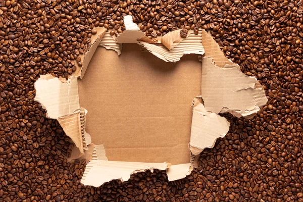 引き裂かれた段ボール紙の中のコーヒー豆 コーヒー豆の背景とコピースペース — ストック写真