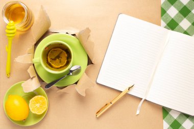 Limonlu çay ve yırtık kağıtta bal. Bardak dolusu yeşil çay.