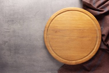 Taş arka plandaki masa masasında tahta ve peçete örtüsü kesiyorum. Tahta pizza tahtası.