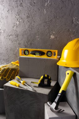 Soyut arkaplan dokusunda tuğlada inşaat aletleri ve beton küp. Sanat veya inşaat konsepti