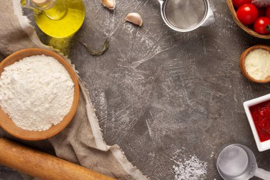 Masada malzemeli ev yapımı pizza. Masa arkasında pizza için un. Mutfakta tarif kavramı