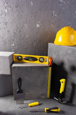 Soyut arkaplan dokusunda tuğlada inşaat aletleri ve beton küp. Sanat veya inşaat konsepti