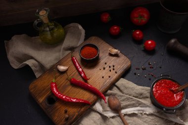 Masadaki ev yapımı yemek için acı biber ve domates sosu malzemesi. Mutfakta kırmızı biber ve tarif konsepti