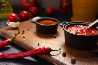 Masadaki ev yapımı yemek için acı biber ve domates sosu malzemesi. Mutfakta kırmızı biber ve tarif konsepti