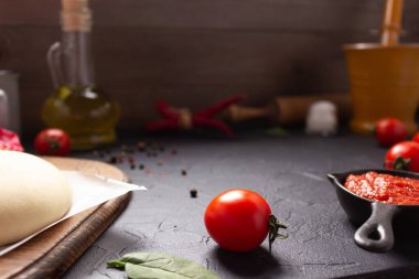 Masadaki malzemelerle ev yapımı pizza ve hamur yemeği. Masa üstü soslu pizza. Mutfakta tarif kavramı