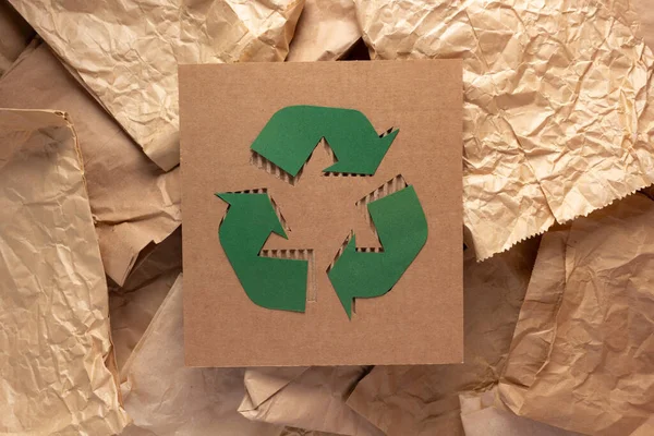 Recycle symbol at cardboard paper as background texture. Recycling idea concept and brown paper