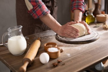 Fırıncı adam masada ev yapımı ekmek pişirmek için hamur ve fırın malzemeleri yapıyor. Fırın konsepti ve erkek eli