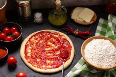 Pizza ve domates sosu ya da malzemeli ketçap. Arka planda pizza pişirmek. Mutfakta tarif kavramı