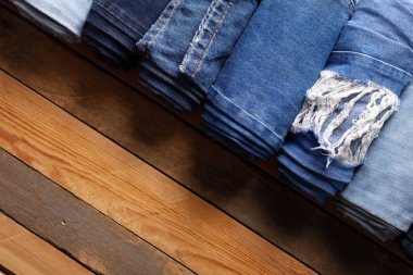 Ahşap arka planda yırtık kot pantolon. Masada Blue Jeans kumaşı