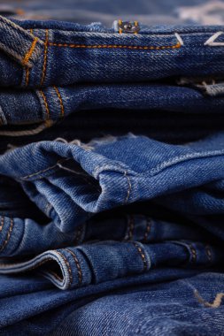 Kot pantolonları arka plan yakın plan. Malzeme yüzeyi olarak kot kumaş yığını