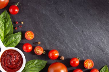 Domates sosu ve fesleğen yapraklı taze domatesler. Masa üstü görünümünde ketçap içeriği