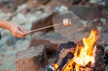 Semi-burnt marshmallows roasting on an open fire.