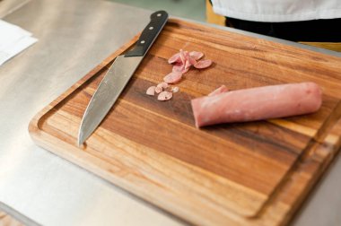 The cook cuts the meatloaf.