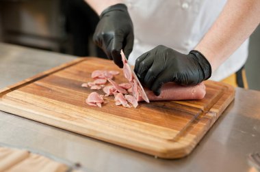The cook cuts the meatloaf.