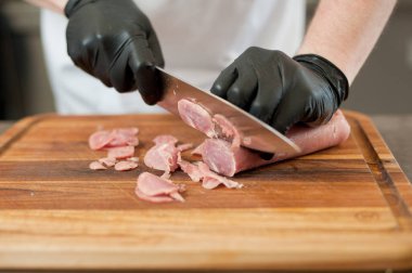 The cook cuts the meatloaf.