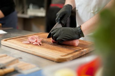The cook cuts the meatloaf.