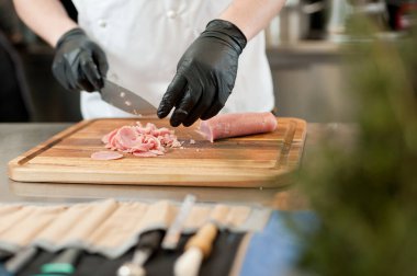 The cook cuts the meatloaf.