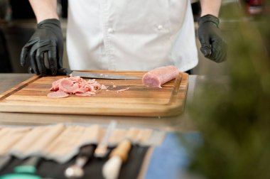 The cook cuts the meatloaf.