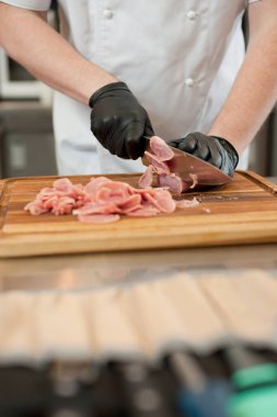 The cook cuts the meatloaf.