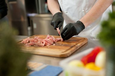The cook cuts the meatloaf.